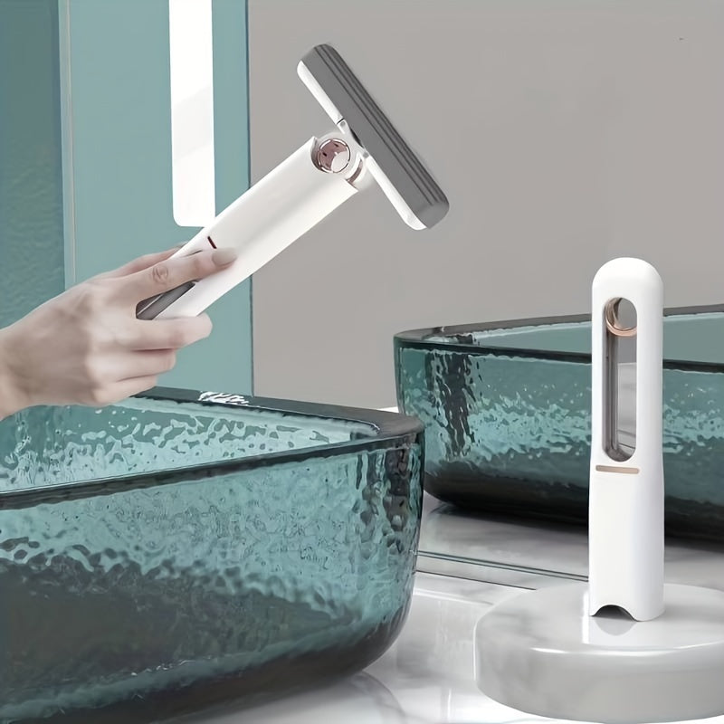 Handheld white mop being used near a modern glass sink, with a second mop standing upright on a counter.