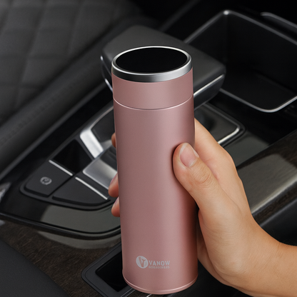 Person holding a pink VANOW thermal flask inside a car.