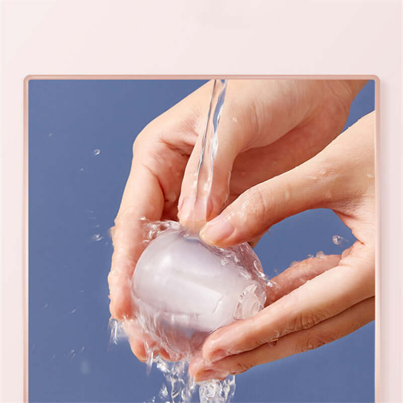 Washing a reusable lint/ pet hair remover ball under running water
