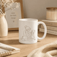 Mother & Daughter Coffee Mug featuring an illustration of a mother and daughter baking together.