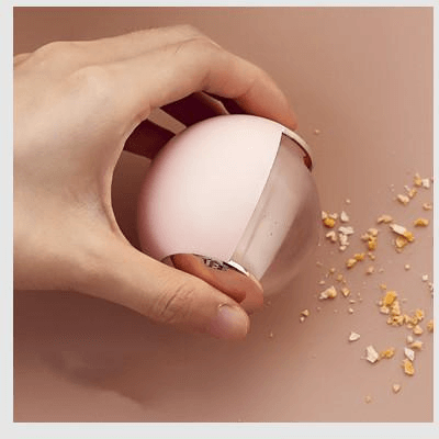 Hand using compact white and pink lint remover on beige background with crumbs